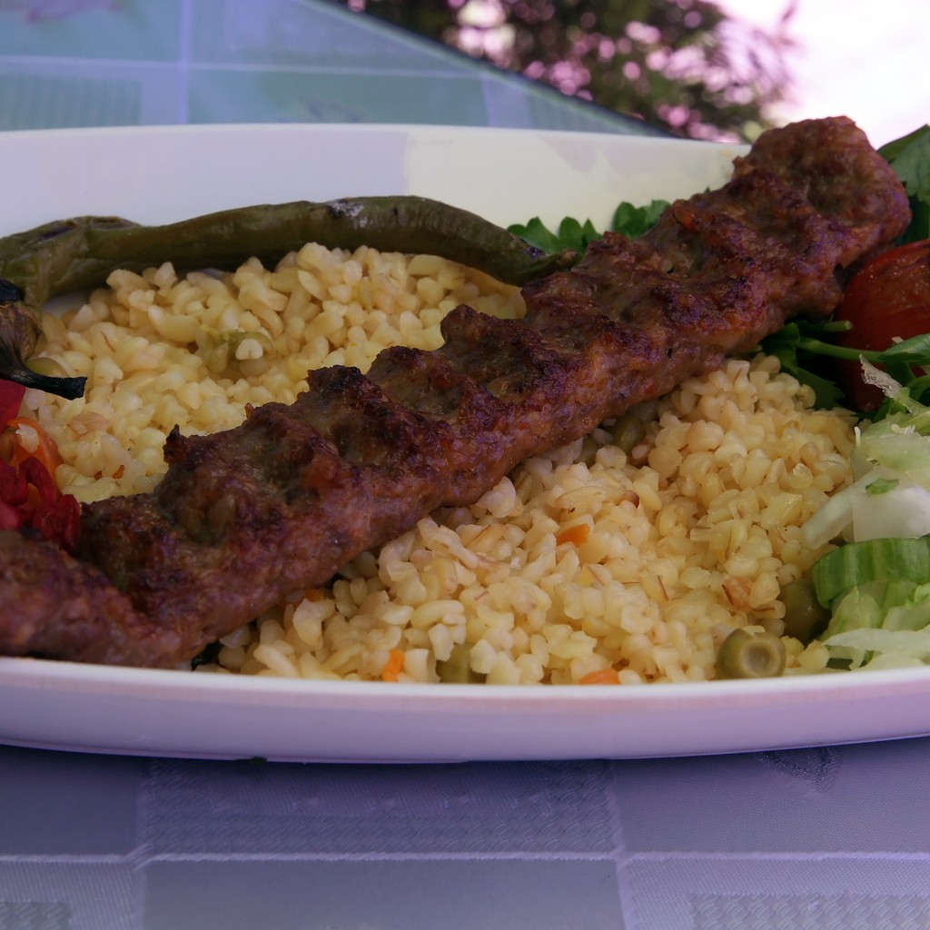 Adana kebab servi avec boulgour, légumes grillés et chou rouge mariné